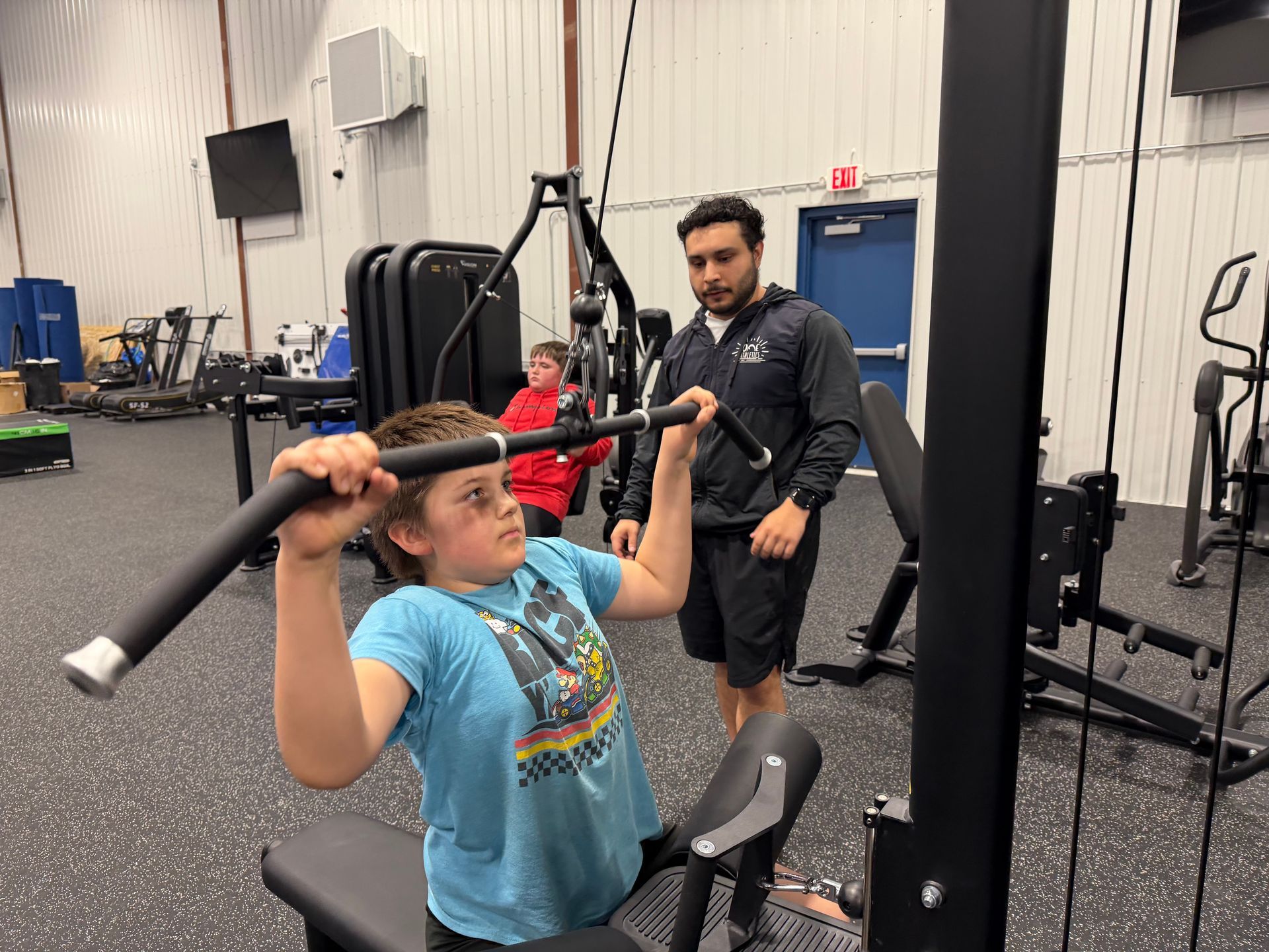Gymnast balancing on uneven bars with coach spotting in a training gym