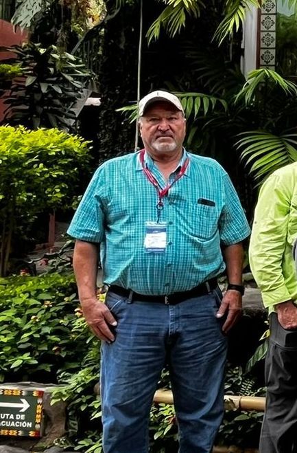 A woman wearing a blue shirt and a black jacket smiles for the camera