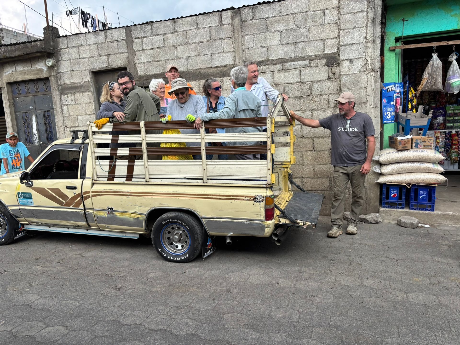 A group of people are sitting in the back of a truck.