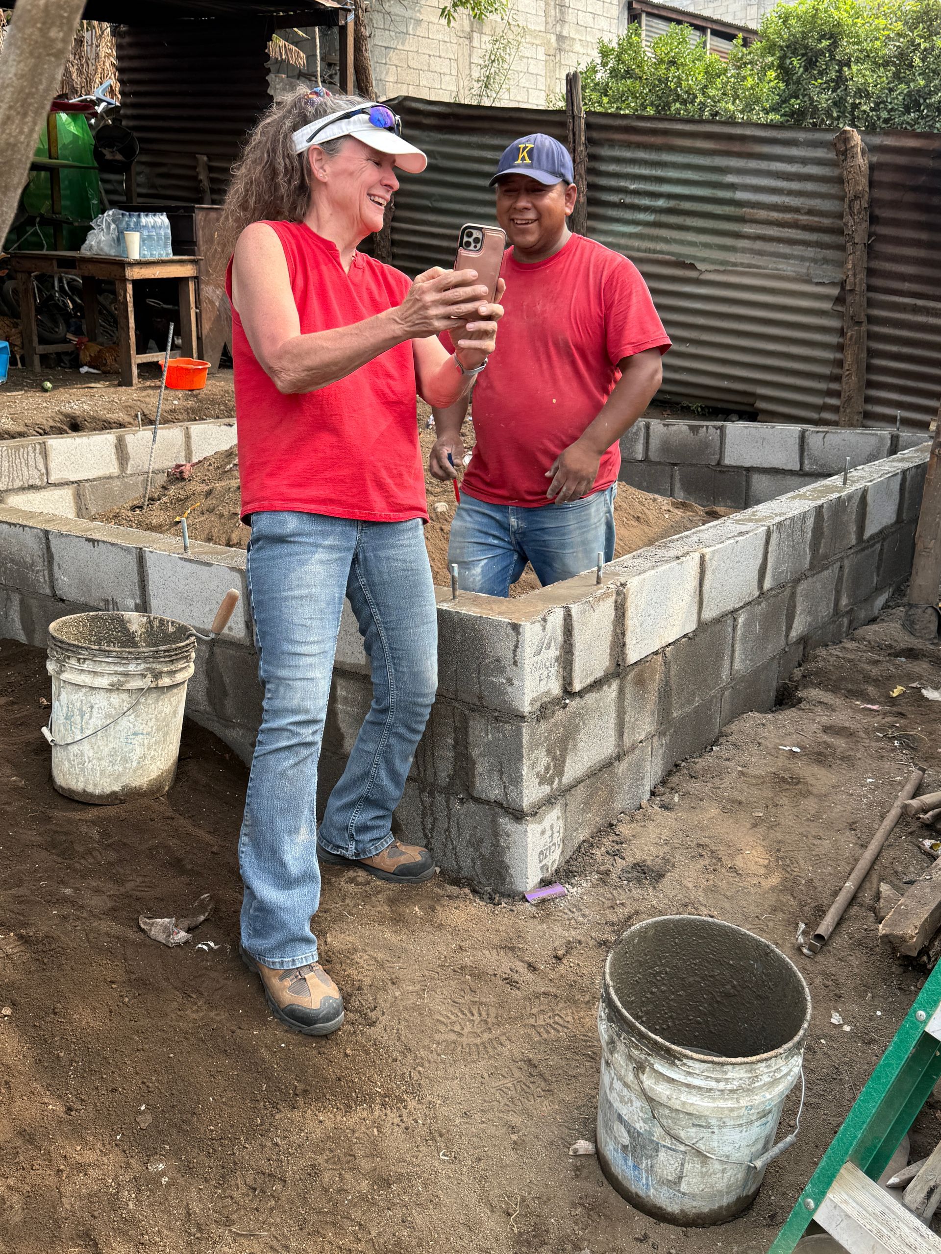 A man and a woman are standing next to each other on a construction site.