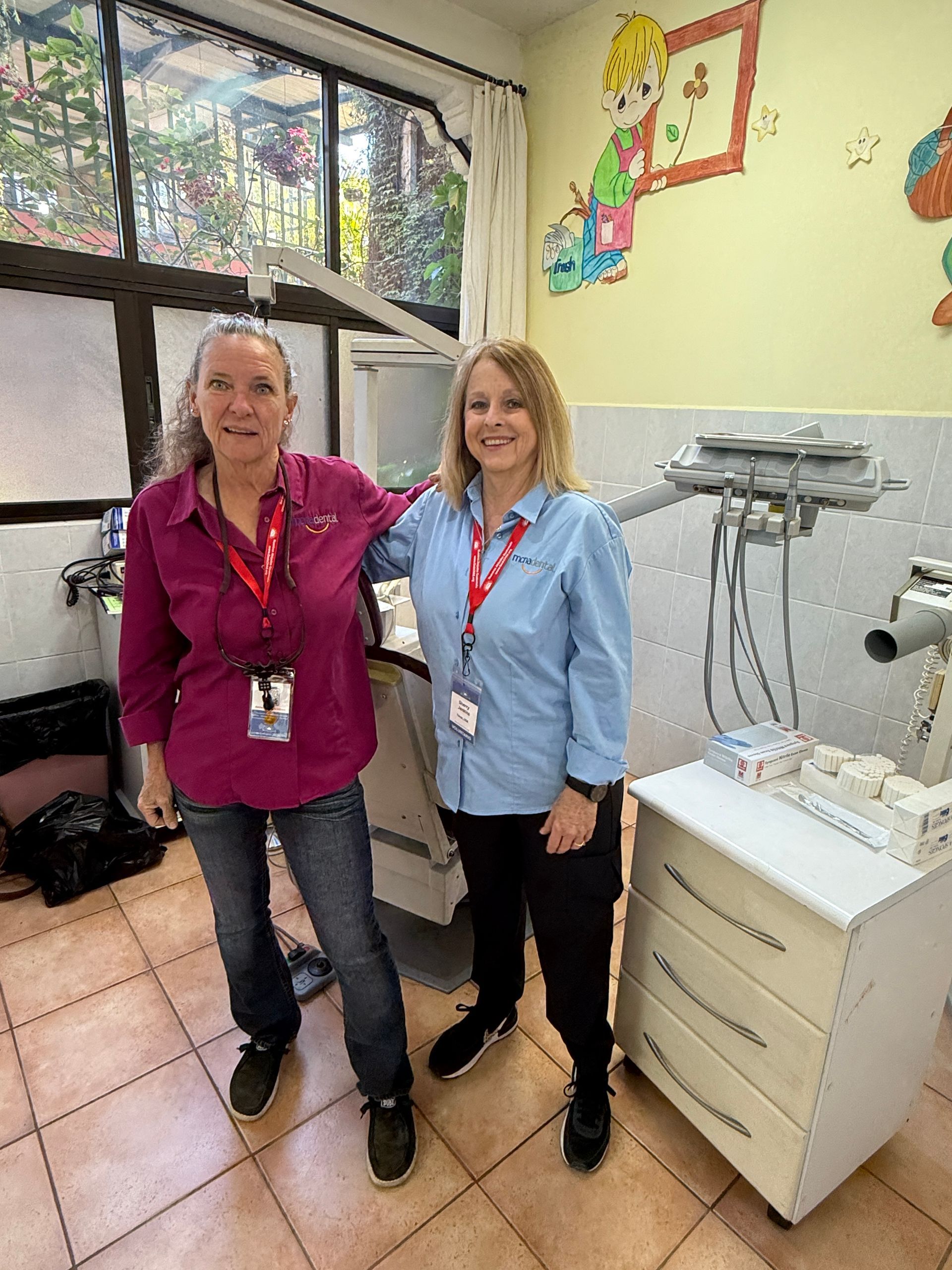 Two women are standing next to each other in a dental office.