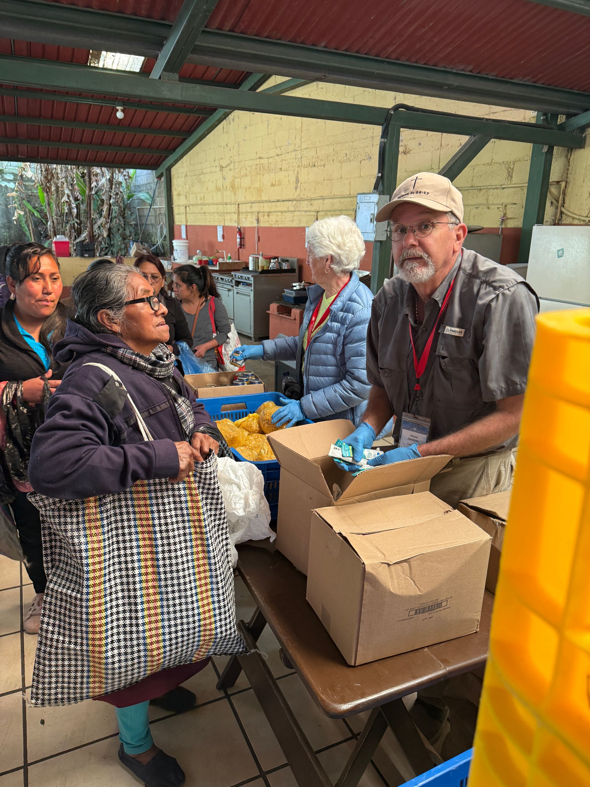 A group of people are standing around a table with boxes on it.