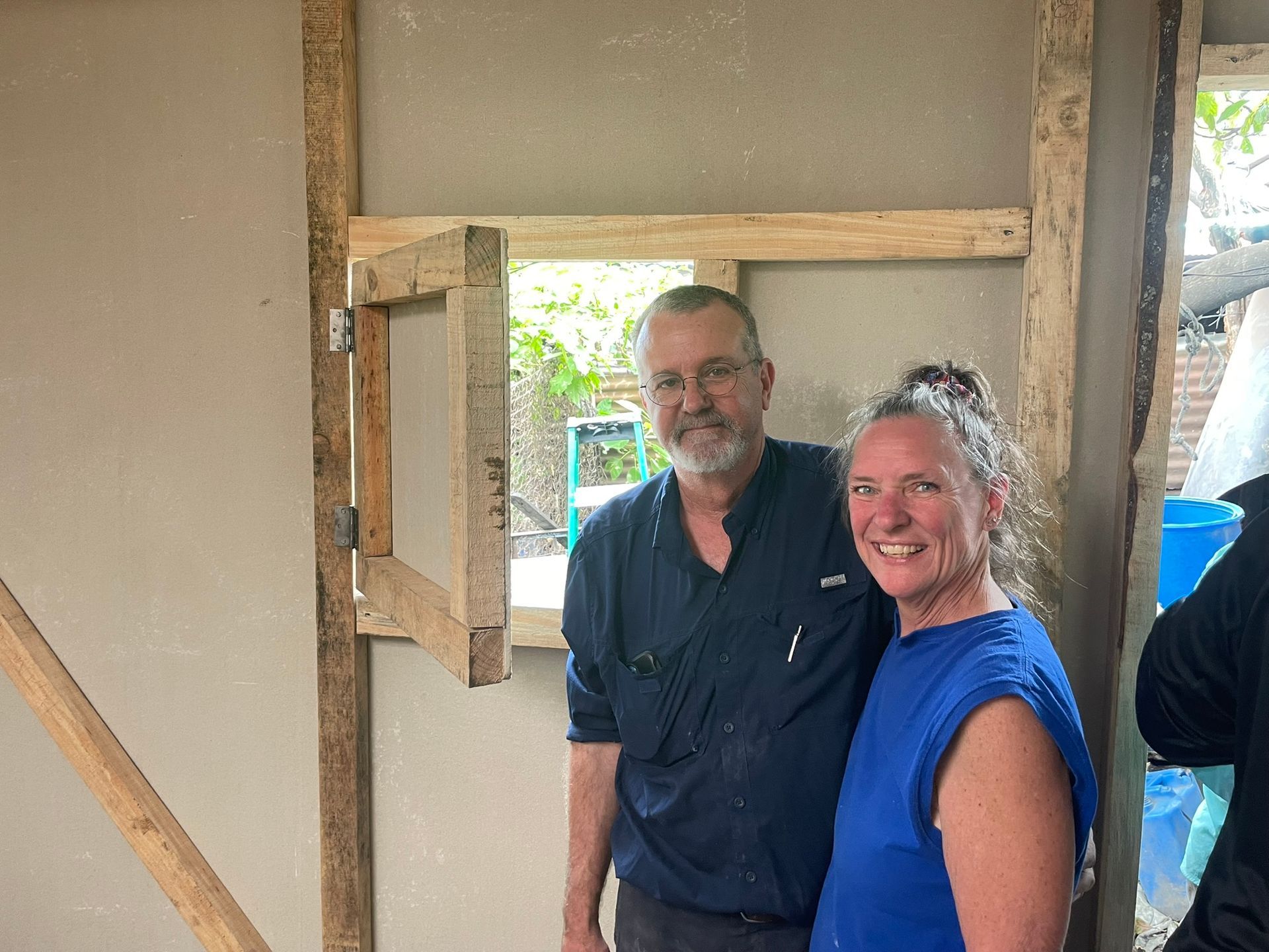 A man and a woman are standing next to each other in a room.