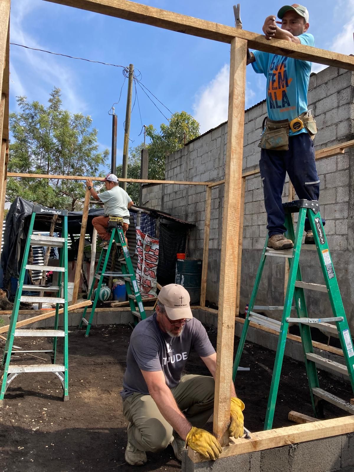 A group of men are working on a wooden structure.