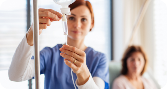 A nurse is preparing an iv for a patient in a hospital room.