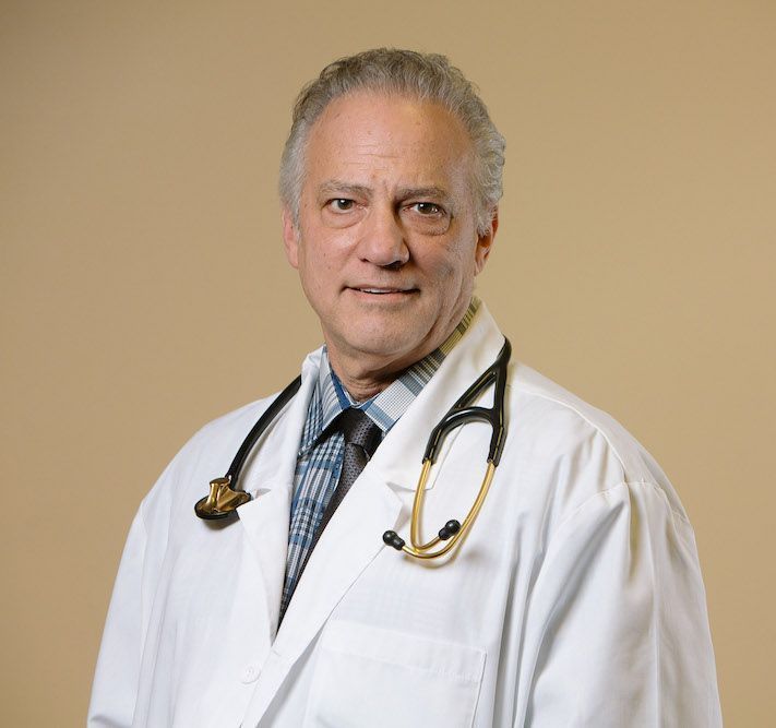 A man in a white lab coat with a stethoscope around his neck