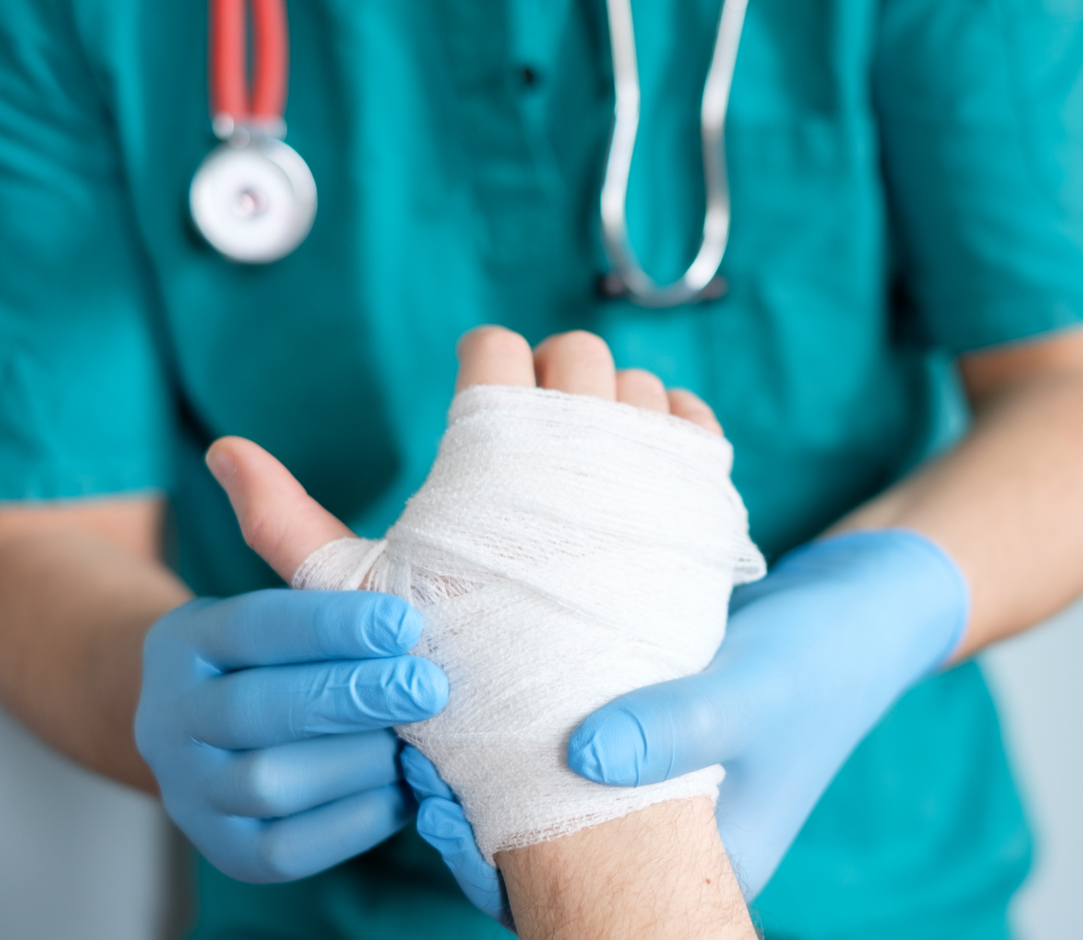A doctor is wrapping a patient 's hand with a bandage.