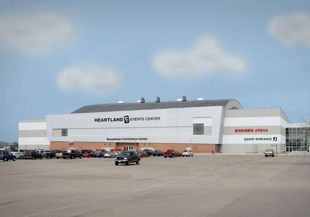 A large building with a lot of cars parked in front of it