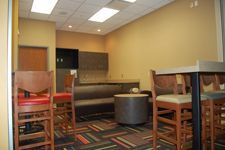 A room with tables and chairs in it and a couch.