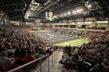 A large crowd of people are watching a football game in a stadium.