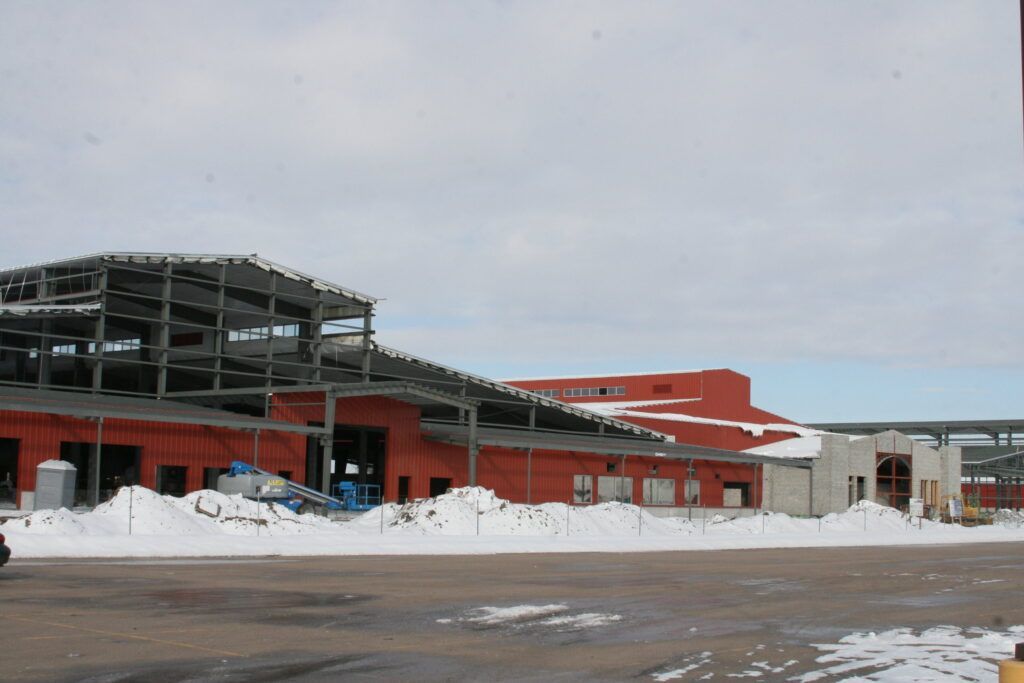 A large building under construction is covered in snow.