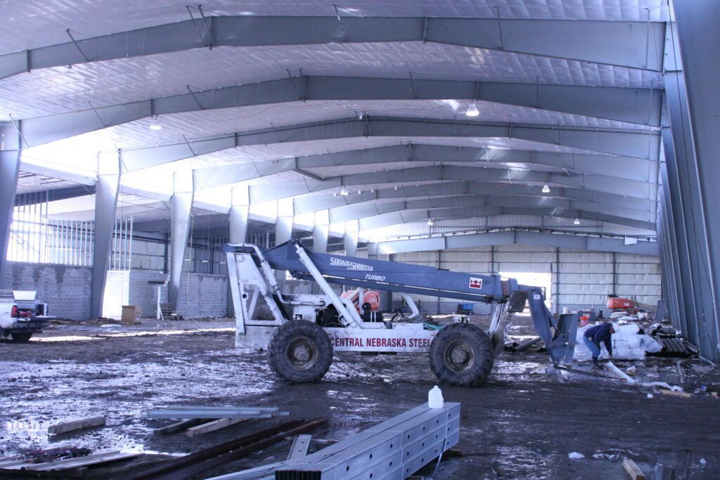 A large building under construction with a tractor in the foreground
