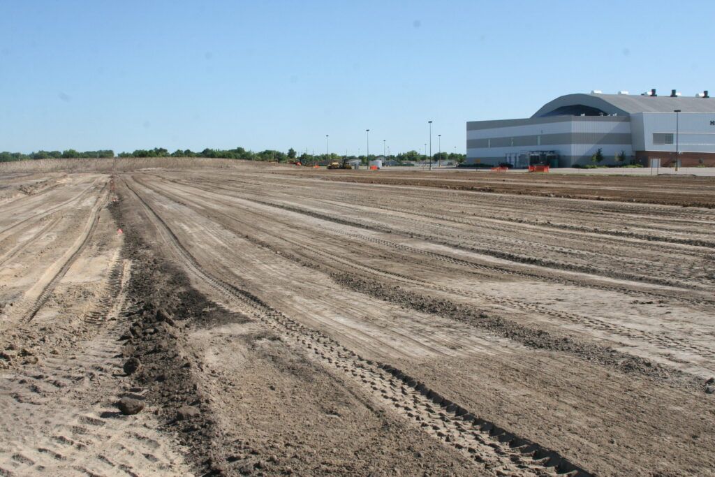 A dirt field with a building in the background