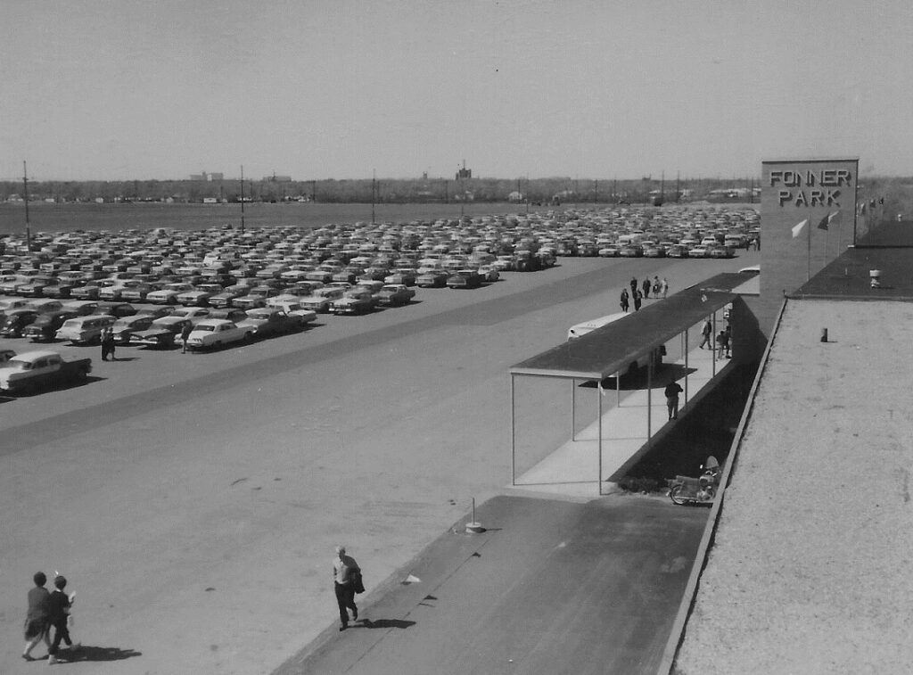 A black and white photo of a parking lot with a sign that says fisher bank