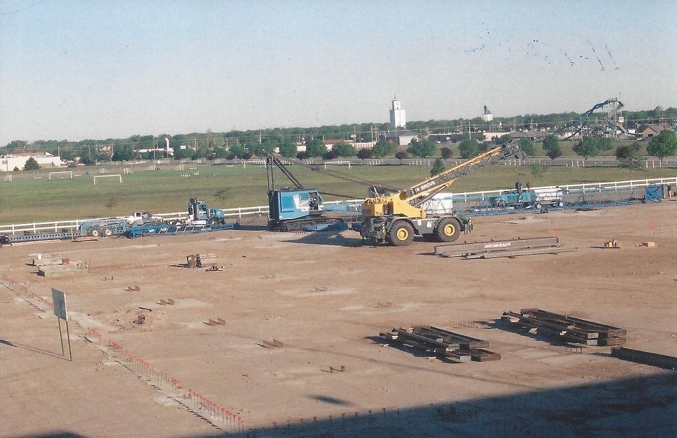 A construction site with a large yellow crane in the foreground