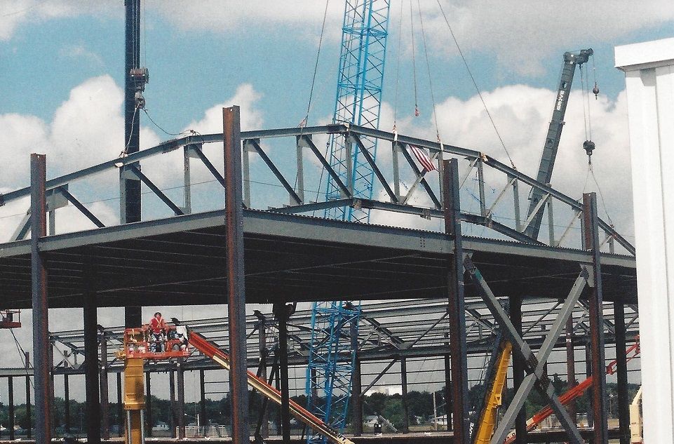 A building under construction with a blue crane in the background