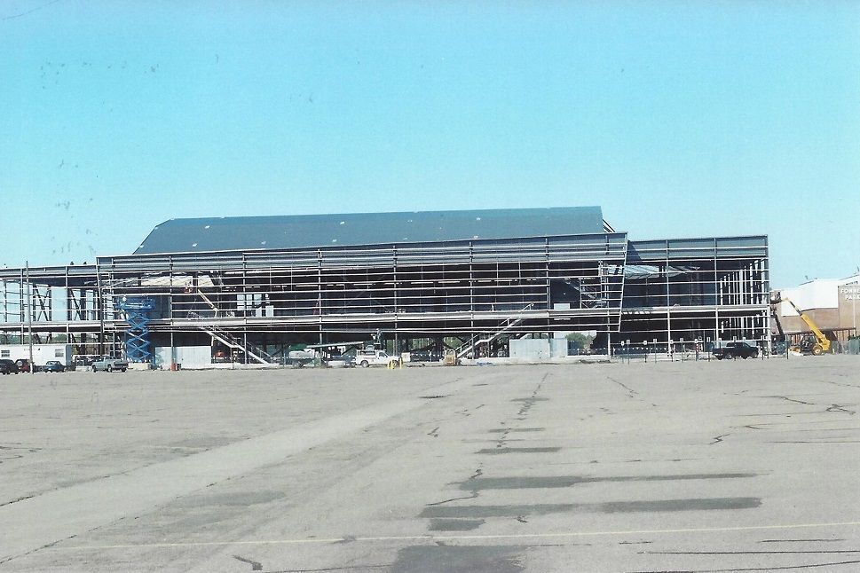 A large building under construction in a parking lot