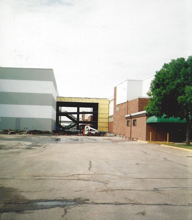A parking lot with a large building in the background