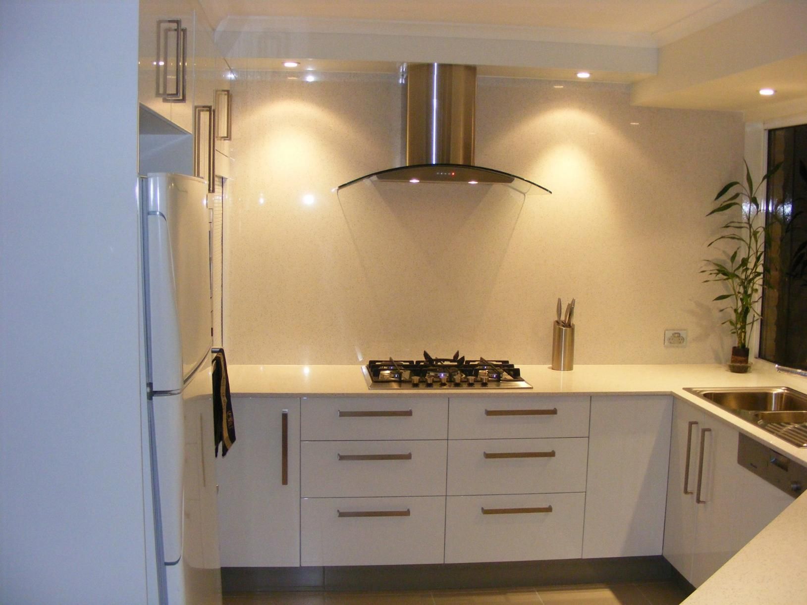 Kitchen With White Cabinets and a Stove Top Oven — Advance Kitchens in Caloundra, QLD