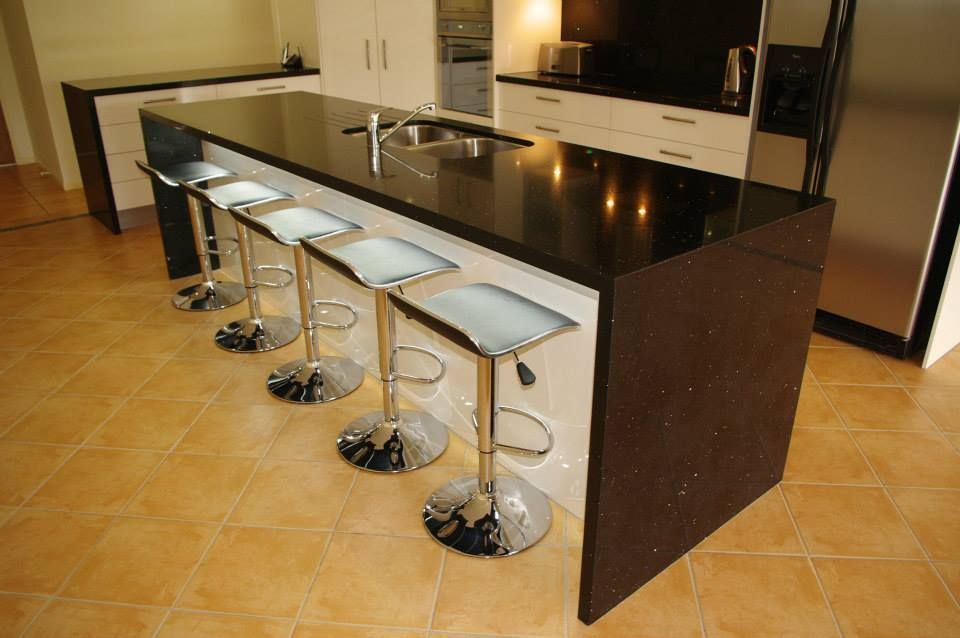 Kitchen With a Black Counter Top and Stools — Advance Kitchens in Caloundra, QLD