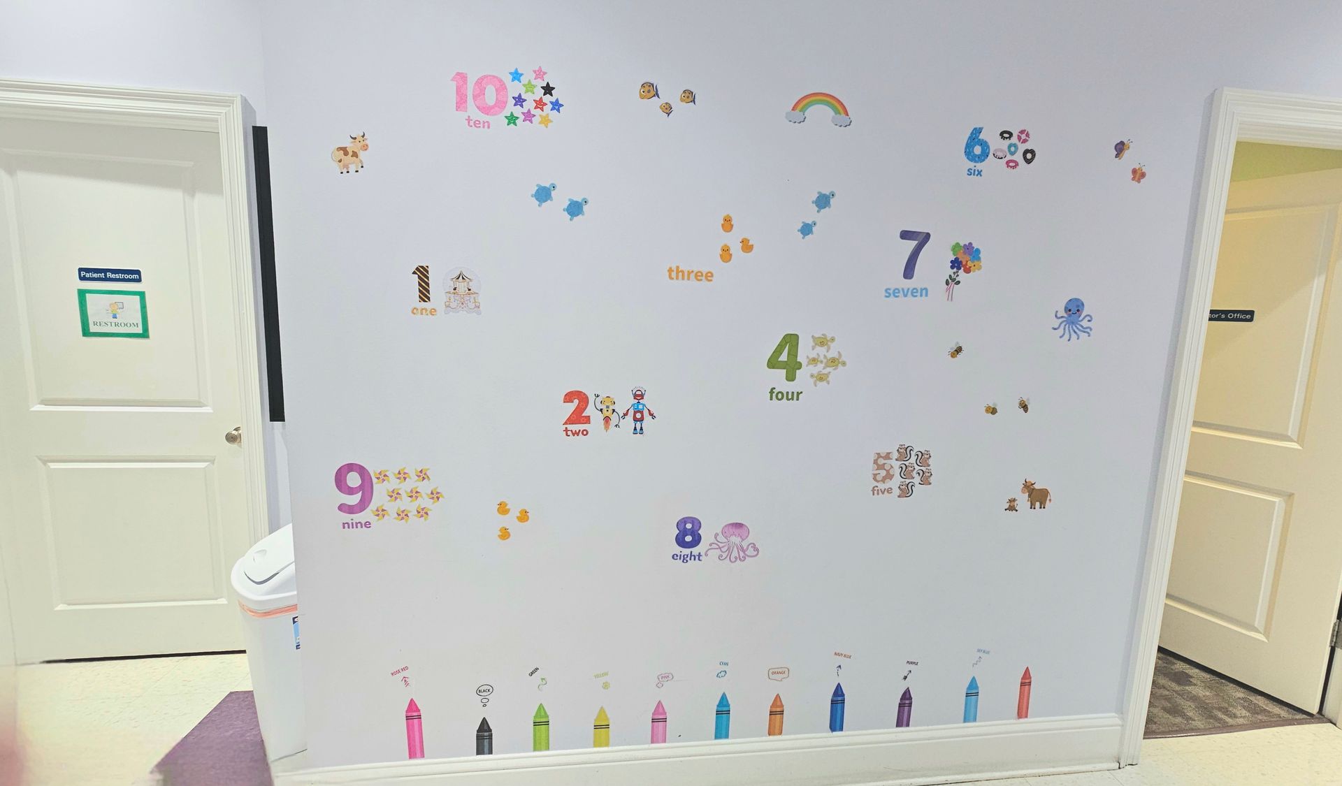 Wall with colorful number stickers and two white doors.