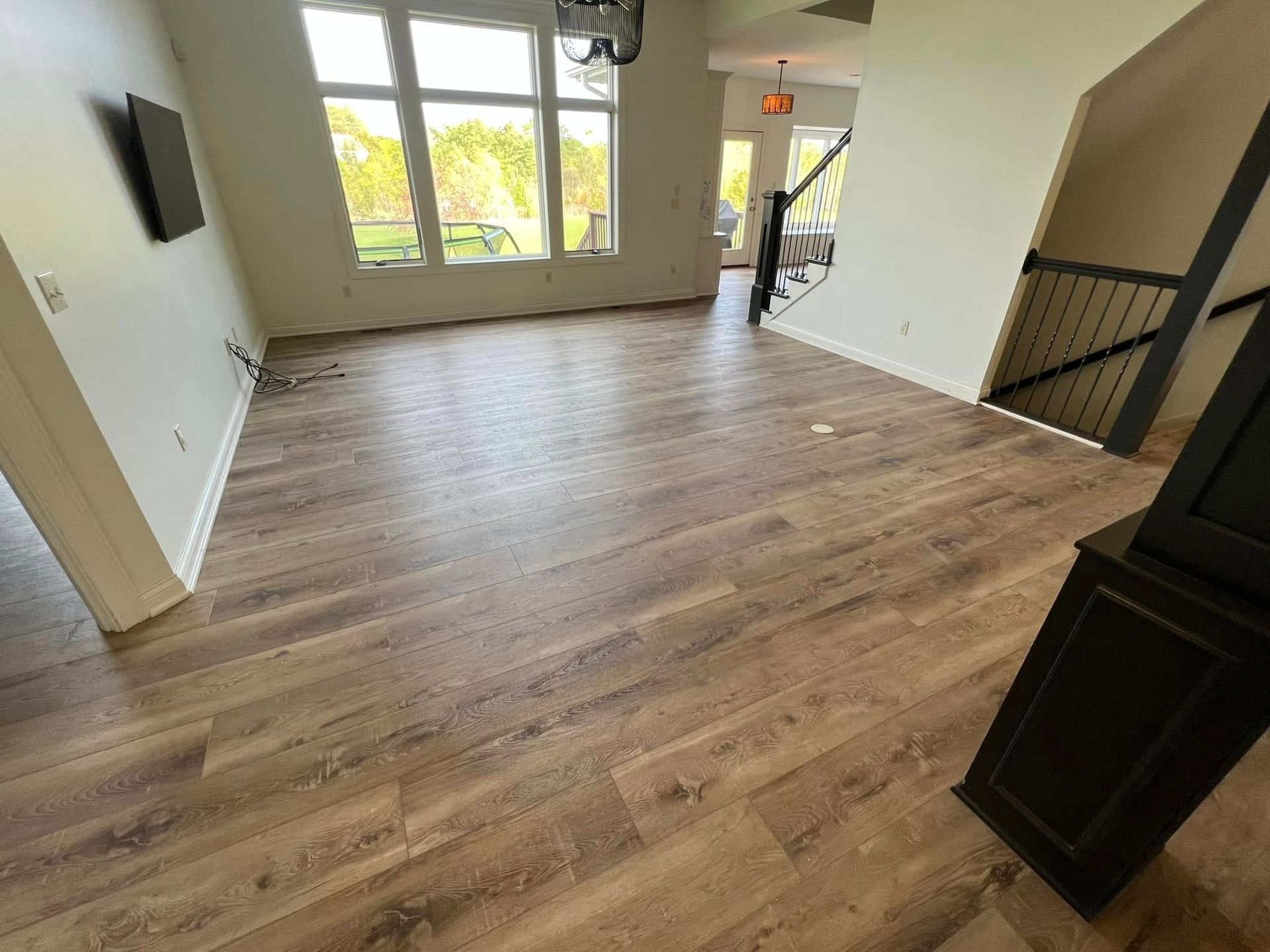 A living room with hardwood floors and a staircase.