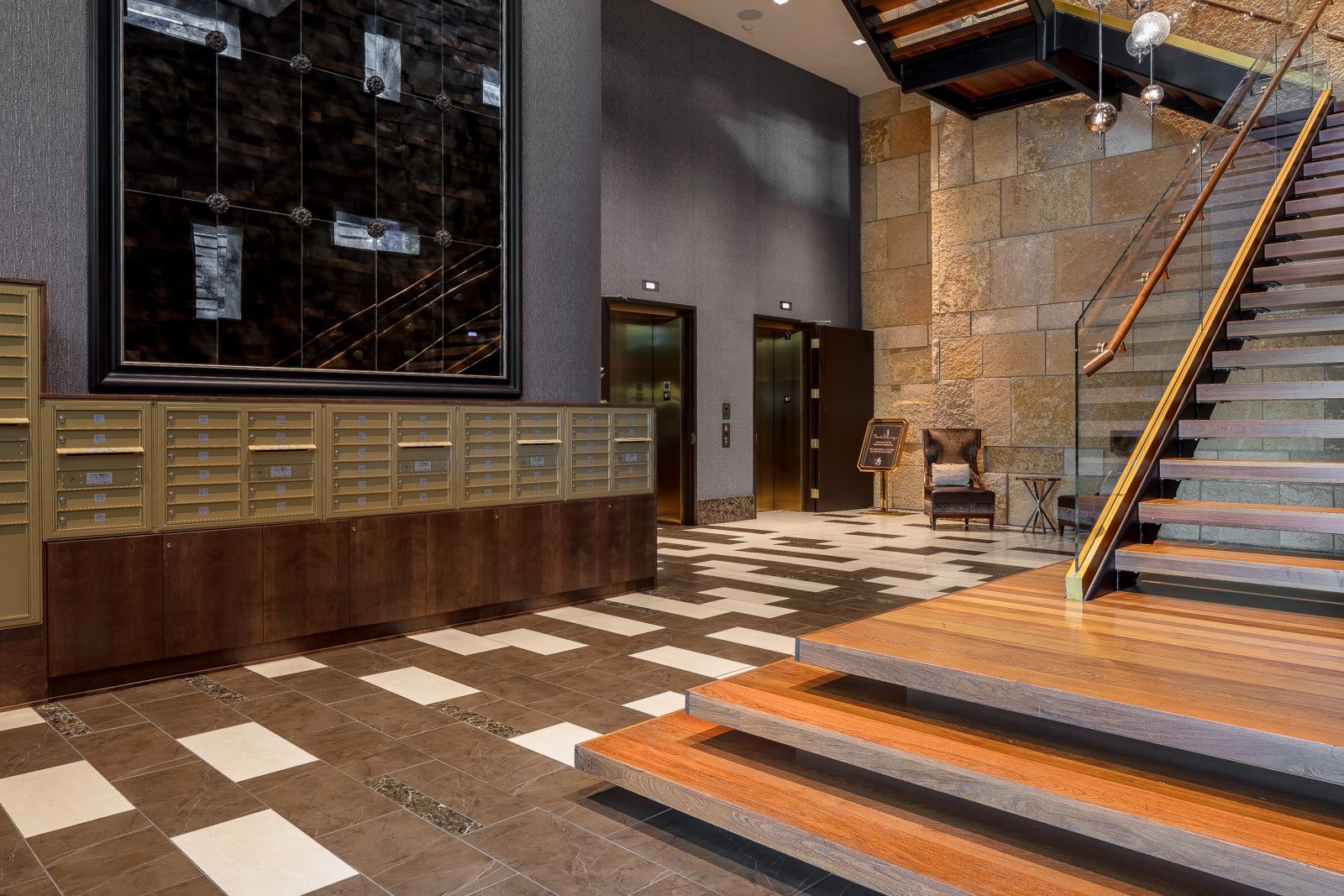Interior lobby with mailboxes, elevators, and a staircase in a modern apartment building at The Walkway, which offers apartments near downtown Minneapolis.
