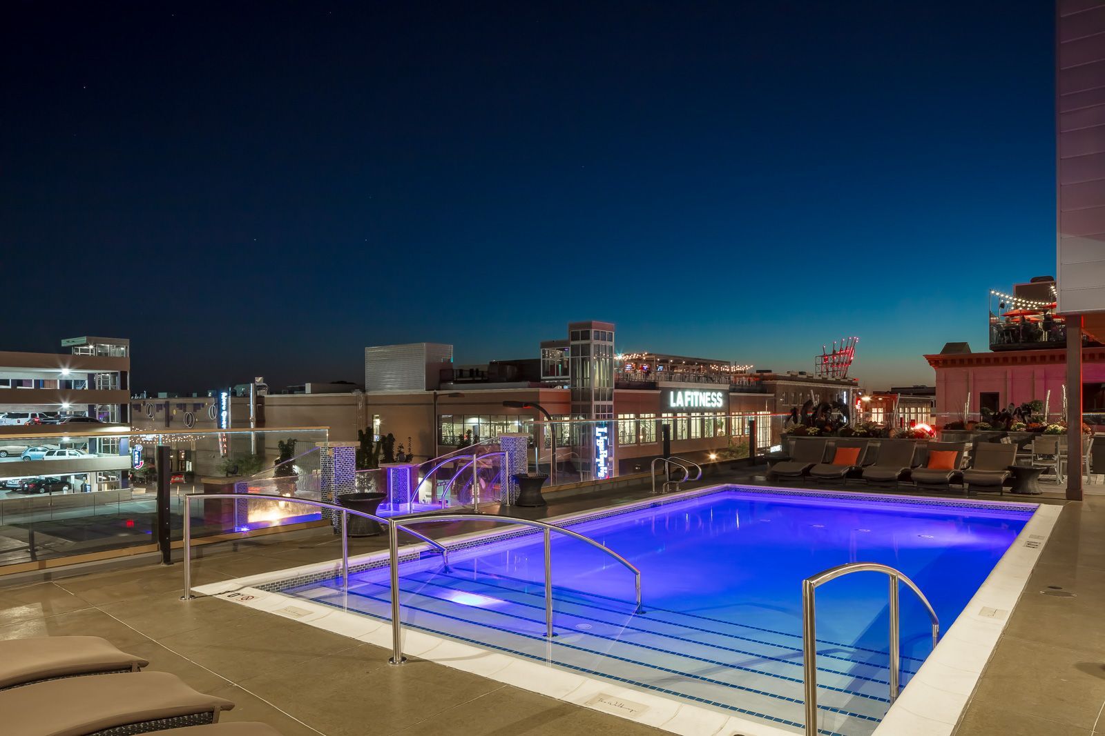 Rooftop pool area at night with lounge chairs and city skyline at The Walkway, which offers pet-friendly apartments in Minneapolis, MN.