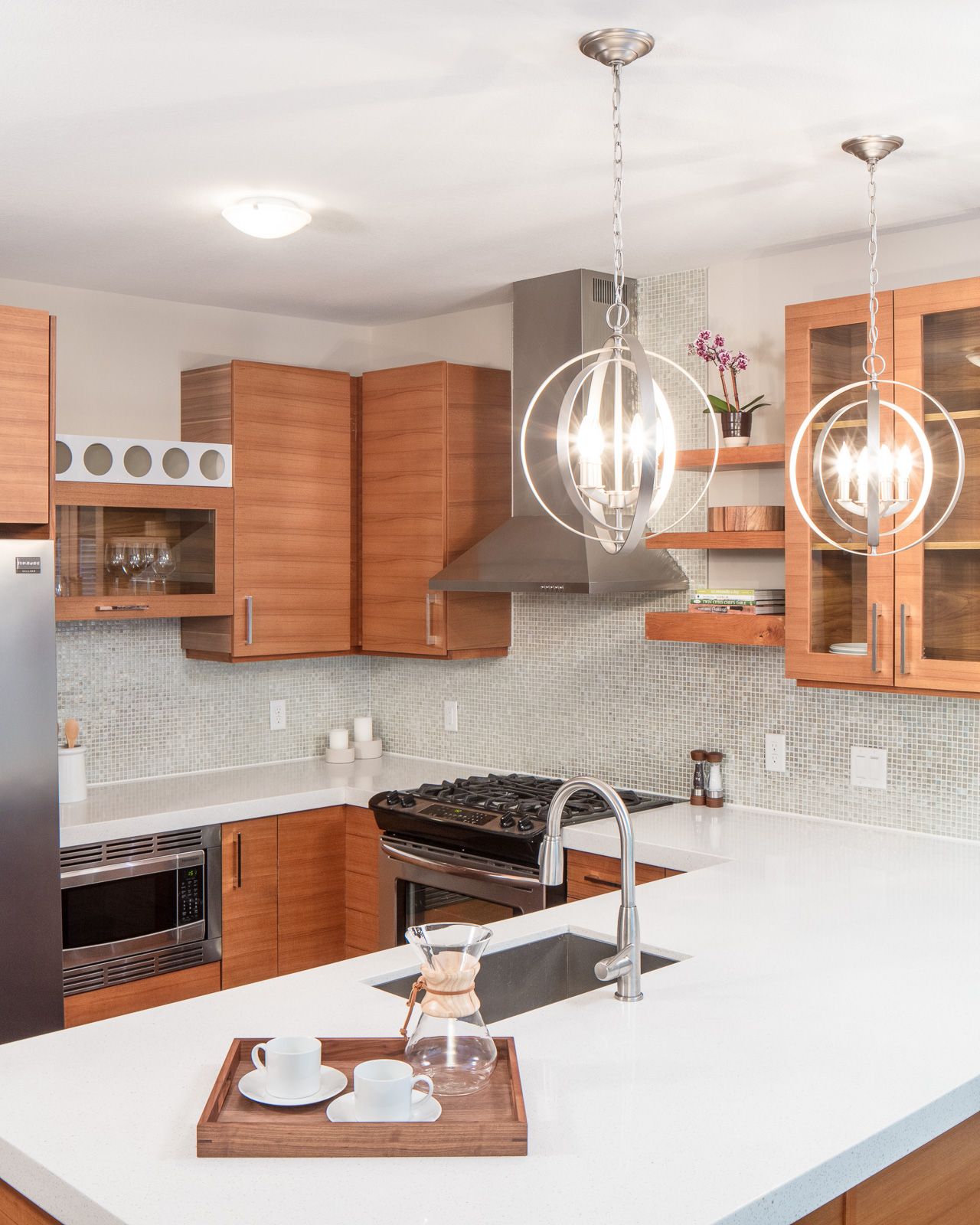 A modern kitchen with warm wood cabinets, white quartz countertops, a central island, and pendant lights at The Walkway, which offers apartments in Uptown Minneapolis, MN.