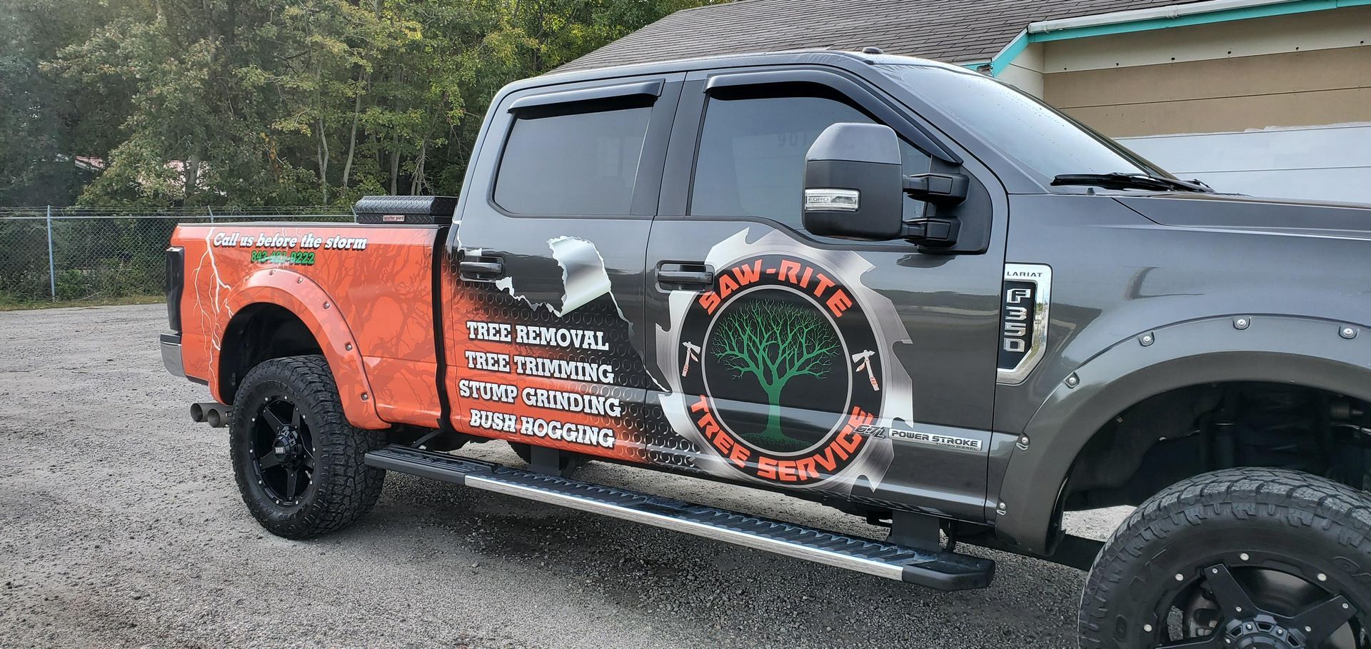 A truck is parked in a gravel lot in front of a house.