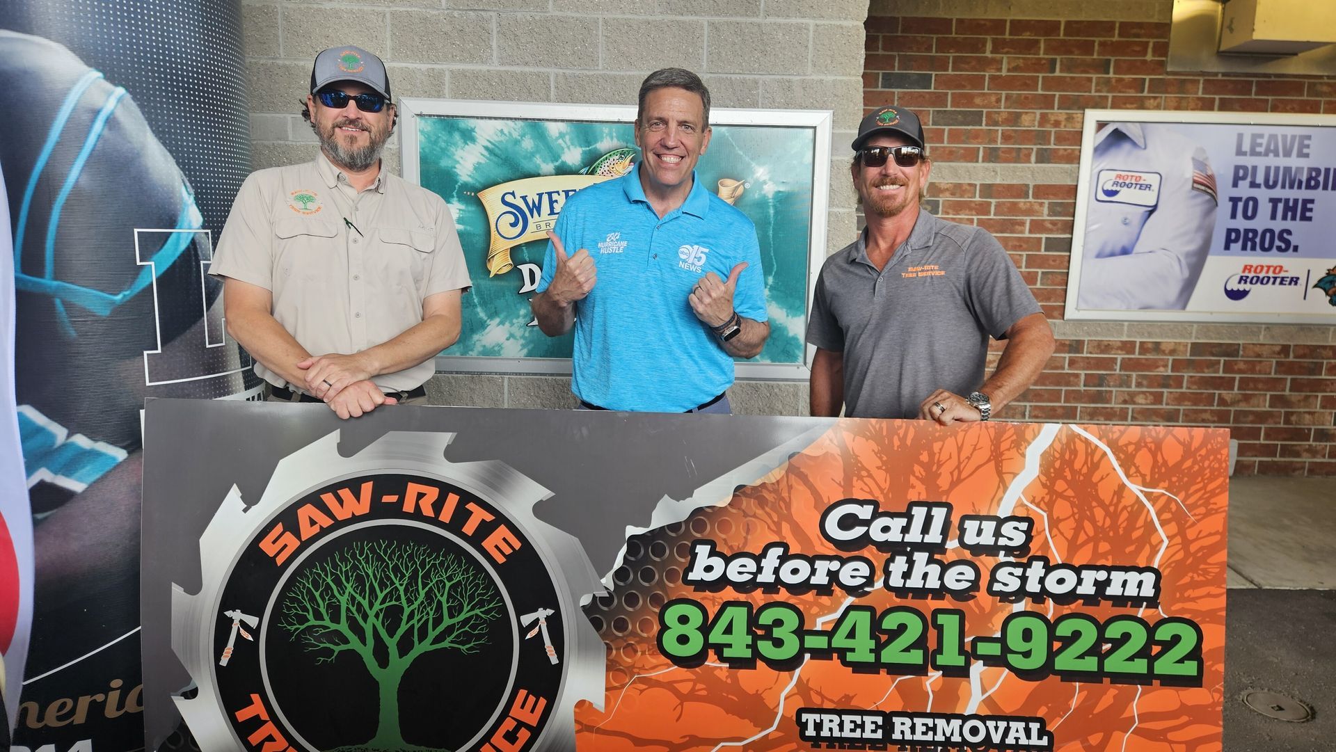 Three men standing in front of a sign that says