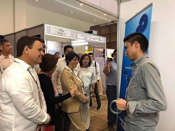 Un grupo de personas están de pie en una habitación hablando entre sí.