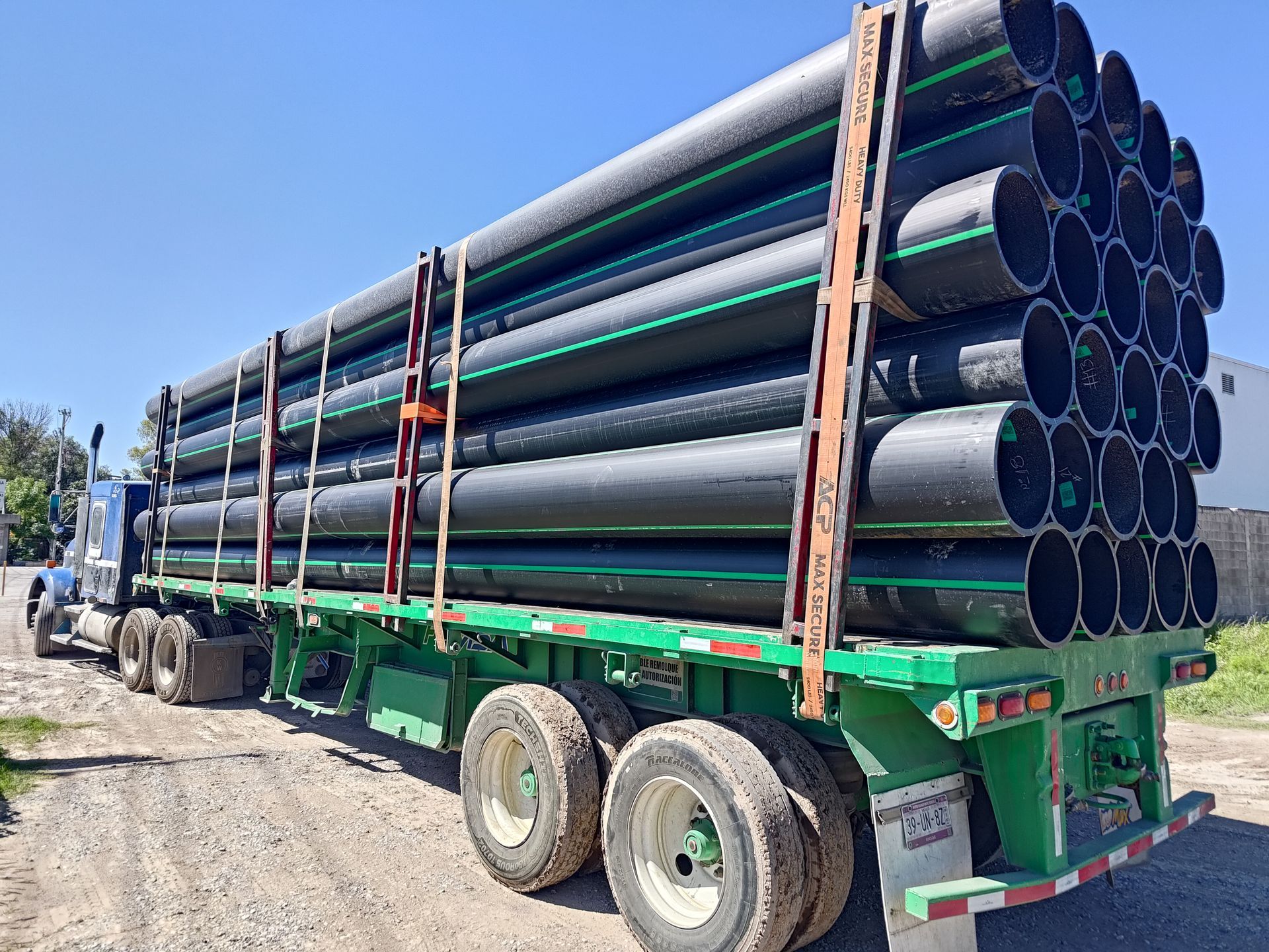 Un camión semirremolque transporta una pila de tuberías en un remolque.