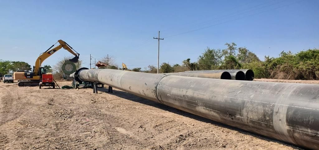 Se está instalando una tubería de grandes dimensiones en un camino de tierra.