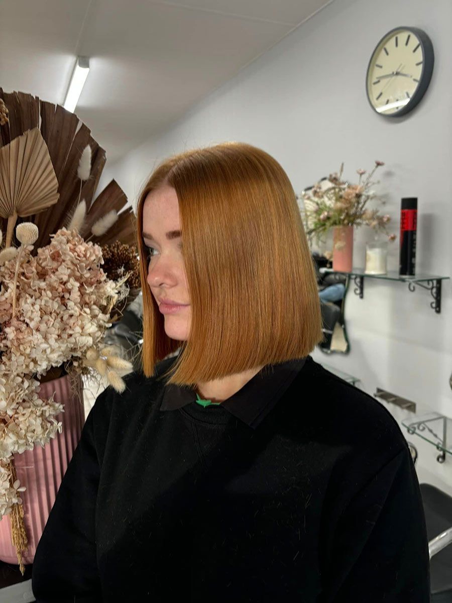 A Woman With Red Hair Is Sitting In A Room — Janine Wellings Hair Art In Belmont, NSW