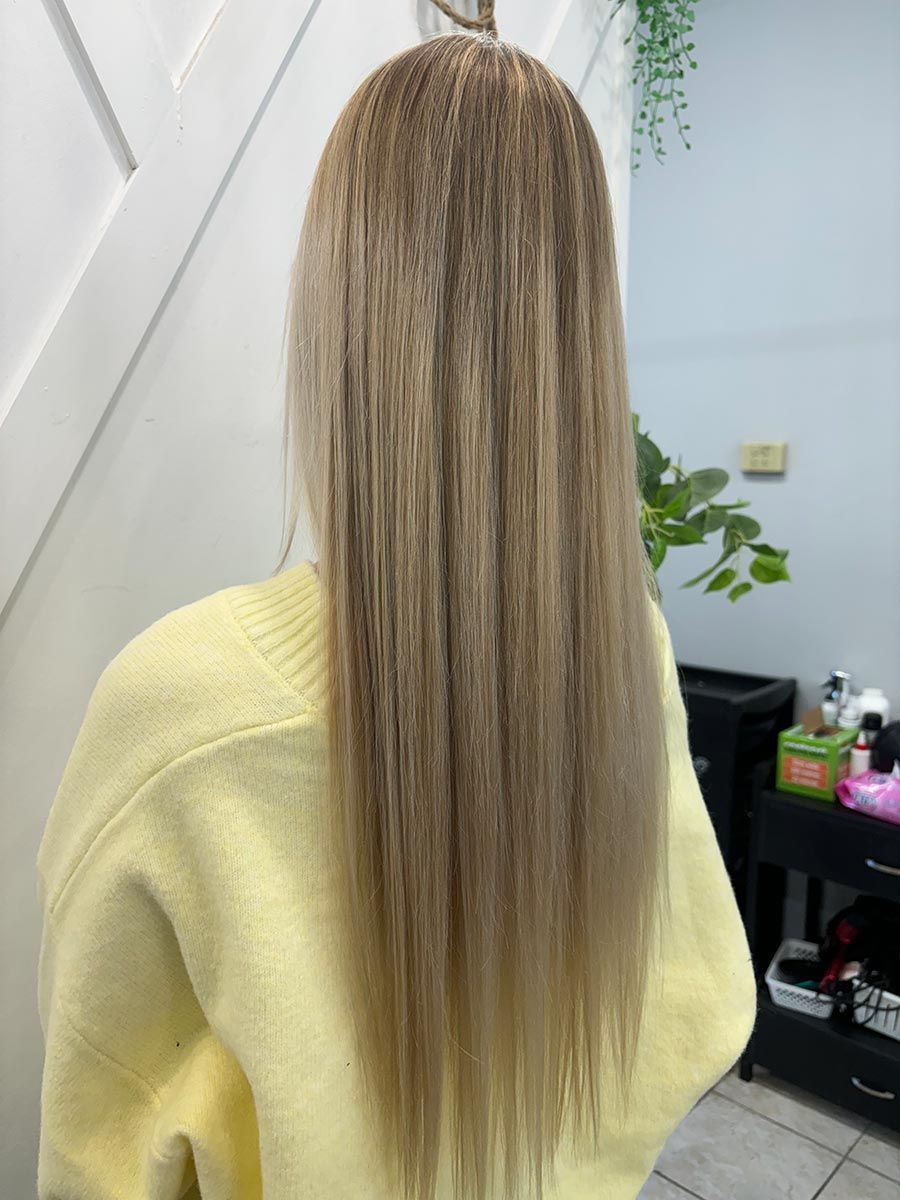 A Woman With Long Blonde Hair Is Wearing A Yellow Sweater — Janine Wellings Hair Art In Belmont, NSW