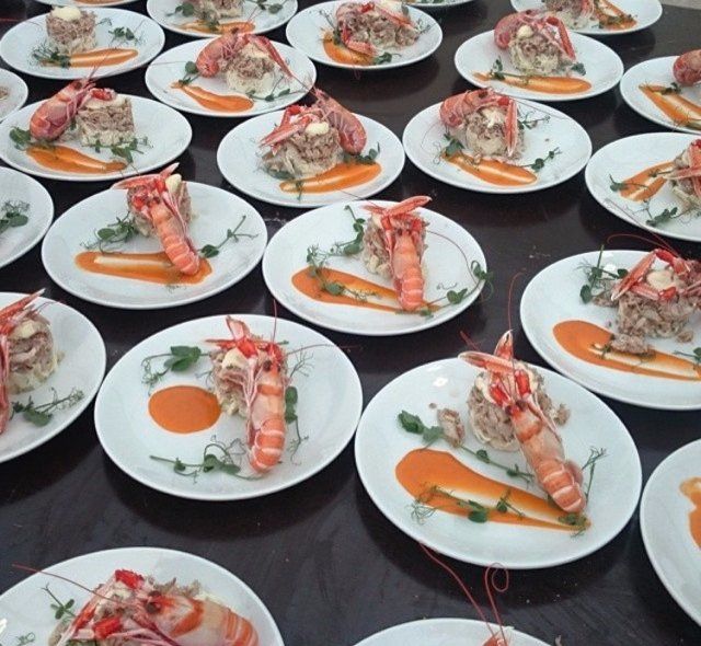 A bunch of plates of food with shrimp on them