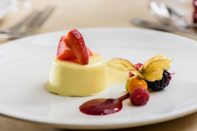 A white plate topped with a dessert with strawberries and raspberries.
