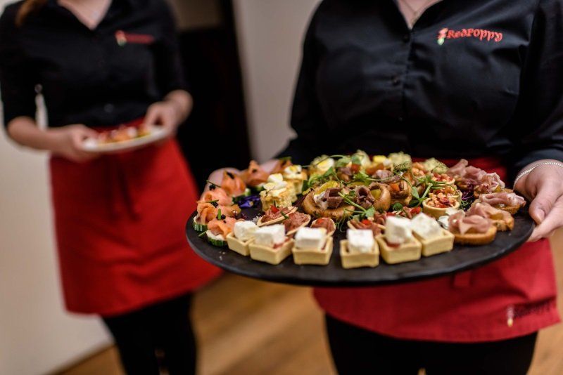 A woman is holding a tray of food in her hands.