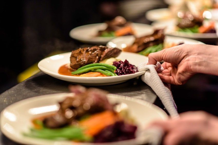 A person is holding a napkin over a plate of food.