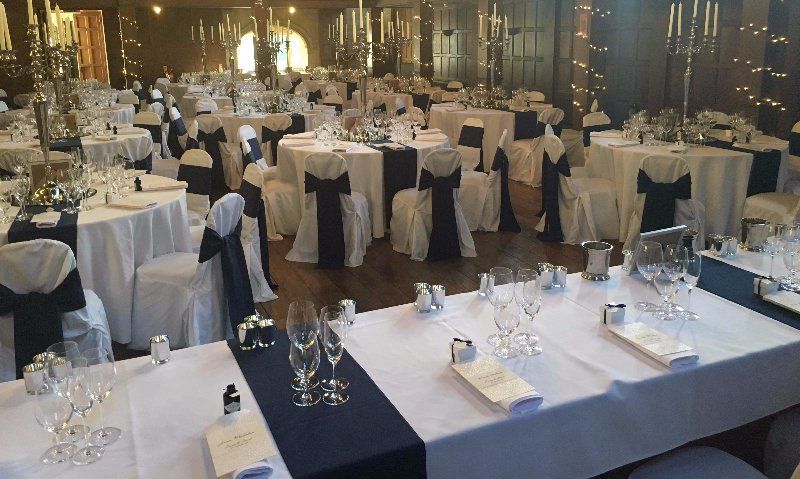 A large room with tables and chairs set up for a wedding reception