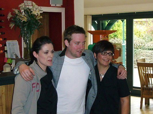 A man and two women pose for a picture in a living room