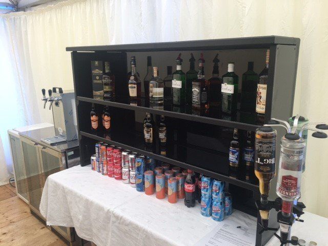 A shelf filled with bottles and cans of alcohol.