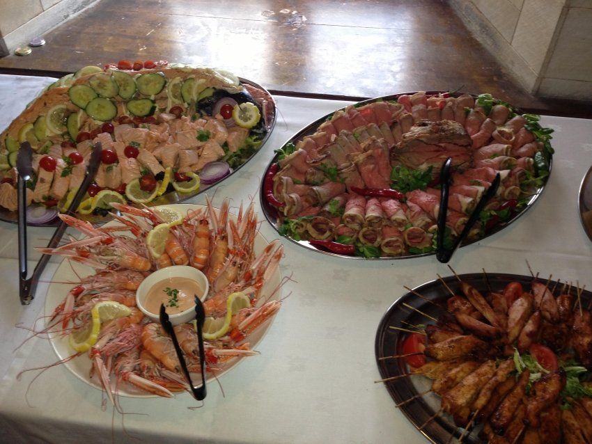 A table topped with plates of food and tongs.