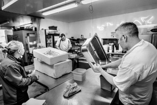 RedPoppy Catering, Inverness, Highlands A black and white photo of a man and a woman working in a kitchen.
