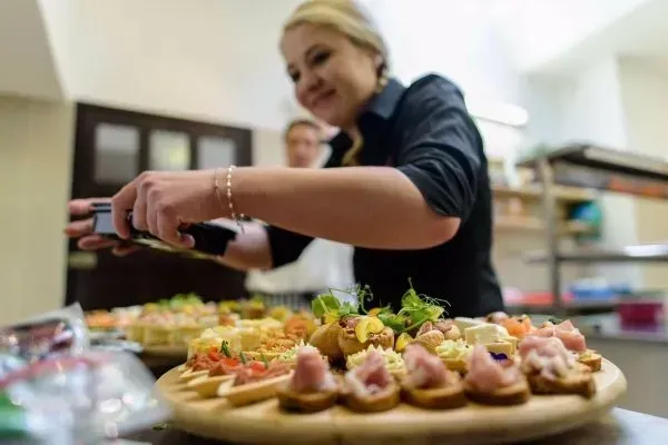 RedPoppy Catering, Inverness, Highlands A woman is preparing food on a wooden cutting board.