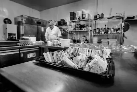 RedPoppy Catering, Inverness, Highlands A black and white photo of a chef preparing food in a kitchen.