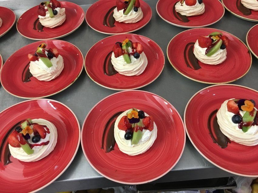 A bunch of red plates with desserts on them