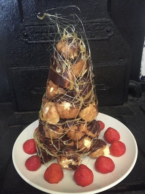 A white plate topped with strawberries and a dessert shaped like a christmas tree
