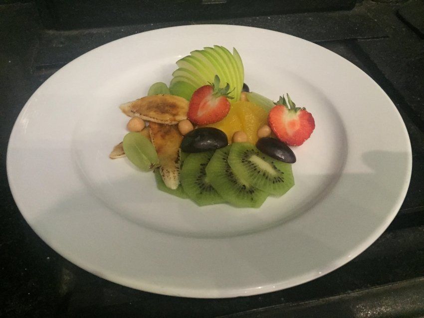 A white plate topped with sliced fruit and nuts